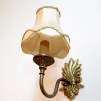 Vintage-Wandleuchte mit cremefarbenem Stoffschirm und edlen goldfarbenen Details
