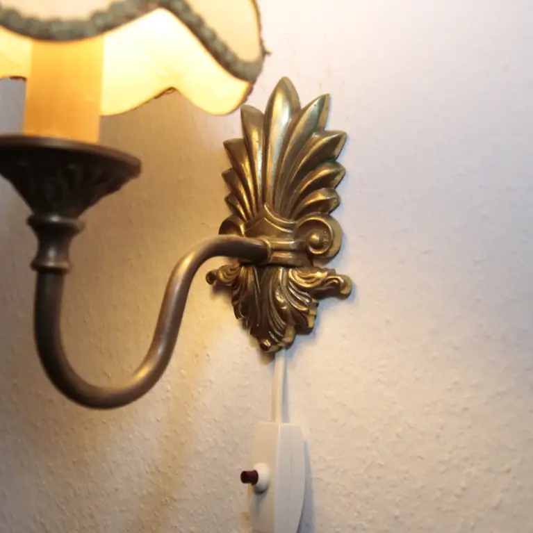 Vintage-Wandleuchte mit cremefarbenem Stoffschirm und edlen goldfarbenen Details